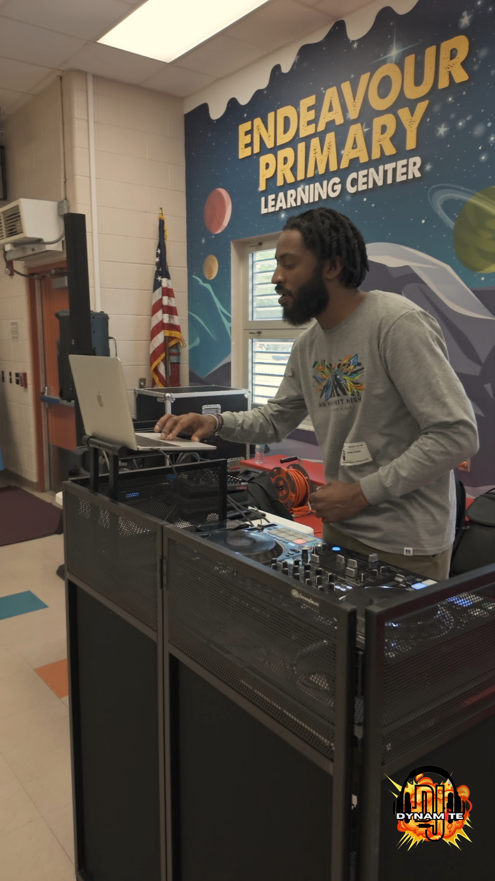 DJ booth, speaker, and cases set in a venue
